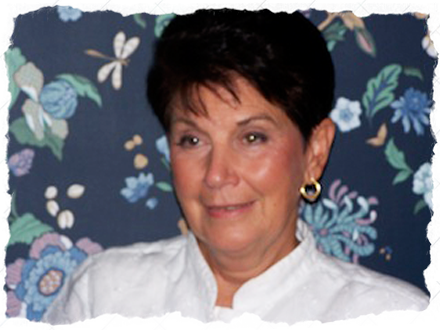 A woman with short hair wearing white shirt and earrings.